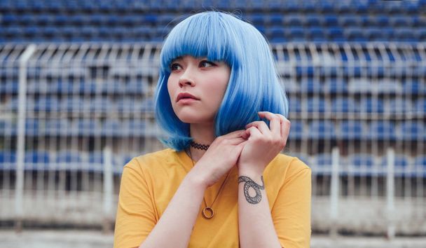 Asian teenager with blue hair on stadium - Photo, Image