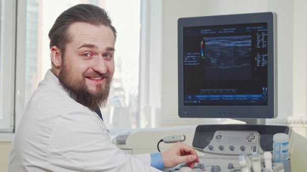 患者の超音波スキャンの結果を調べる男性医師 - 写真・画像