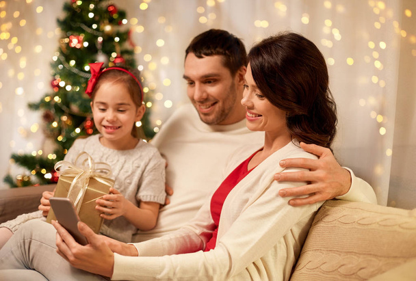 family with smartphone at home on christmas - Valokuva, kuva