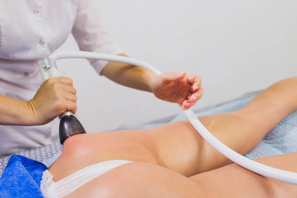 Cropped view of cosmetologist with roller doing buttocks starvac massage. - Fotoğraf, Görsel