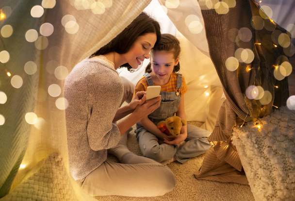 happy family with smartphone in kids tent at home - Valokuva, kuva