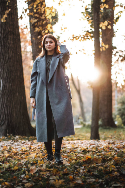 Pretty girl walking in autumn park. Beautiful autumn sunny weather. Young woman enjoying fall. Women fashion. Autumn holidays. People, autumn and lifestyle concept. - Foto, afbeelding