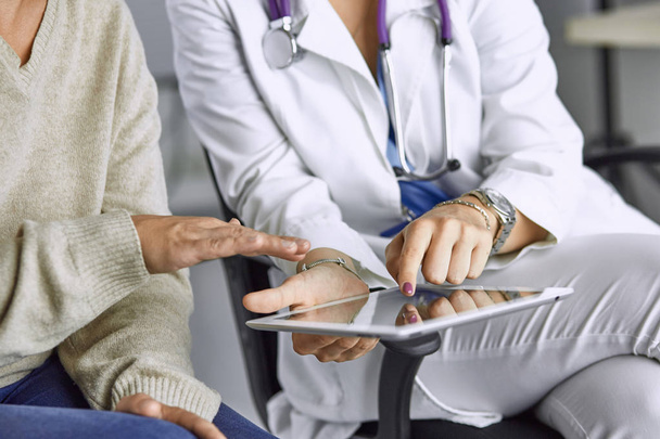 vrouwelijke arts praten met een patiënt op een Tablet - Foto, afbeelding