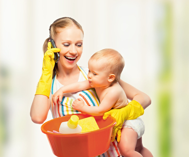 jeune mère heureuse est une femme au foyer avec un bébé fait ses devoirs et
 - Photo, image
