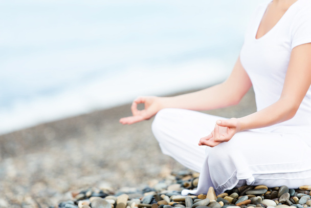 Mano de mujer meditando en una pose de yoga en la playa
 - Foto, imagen