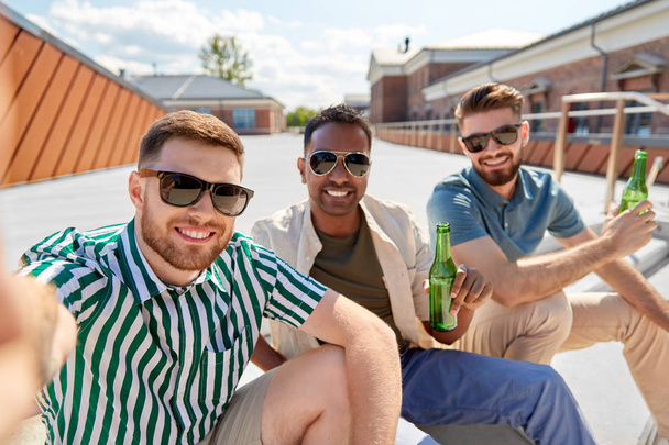 men drinking beer and taking selfie on street - 写真・画像