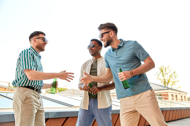 happy male friends with beer meeting on rooftop - Fotoğraf, Görsel
