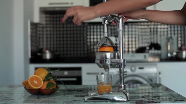 Жінка стискає свіжий апельсиновий сік у соковижималку
 - Кадри, відео