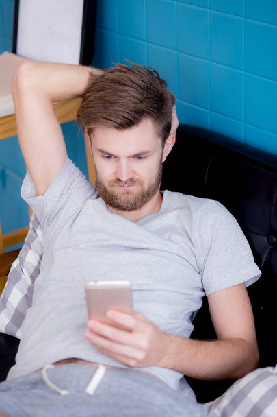 Homme heureux regardant le contenu des médias dans un téléphone intelligent assis sur un c
 - Photo, image