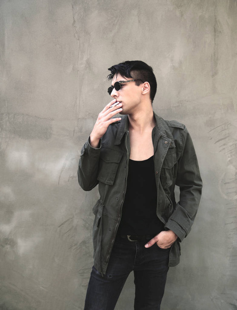 Portrait of young man smoking  outdoors - Photo, Image