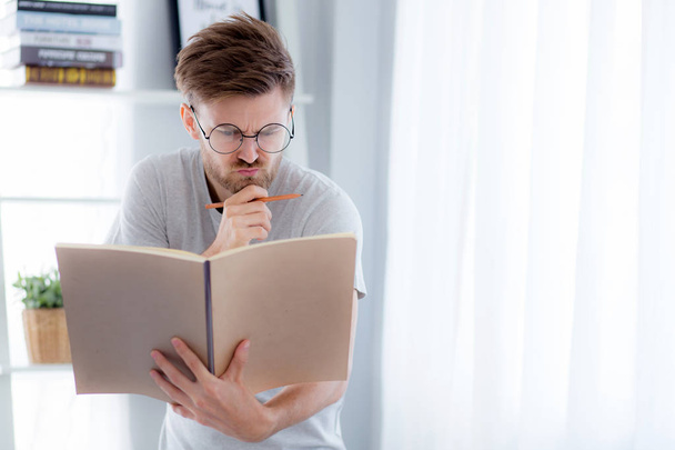 Bello ragazzo in occhiali sta leggendo libro preparazione esame e th
 - Foto, immagini