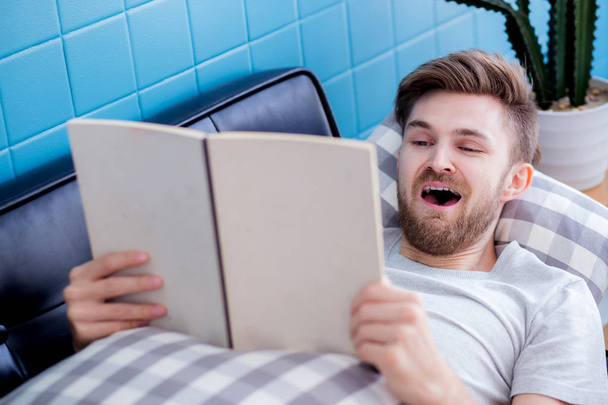 relajarse hombre leyendo un libro acostado en concepto de educación sofá
. - Foto, Imagen