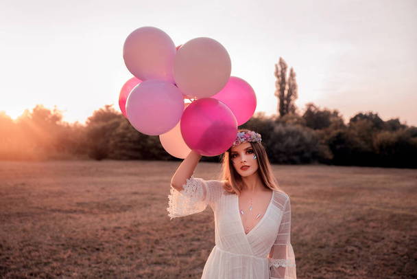 Genç ve güzel bir kadın balonlarla tarlada - Fotoğraf, Görsel