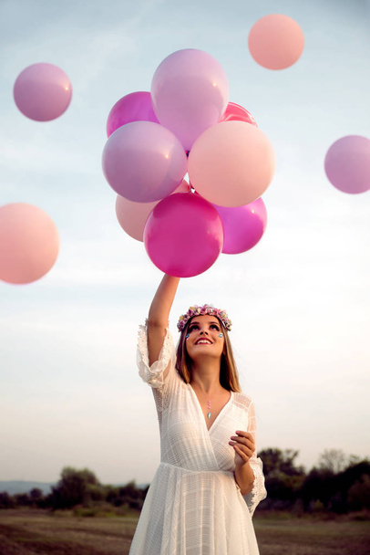 young beautiful woman with balloons in field - Photo, Image