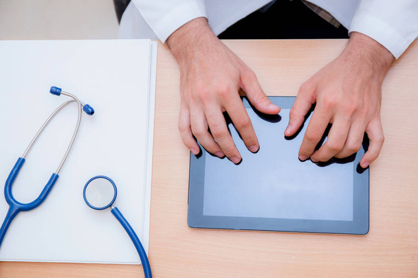 мужчина врач с планшетным компьютером и стетоскопом за столом на
  - Фото, изображение