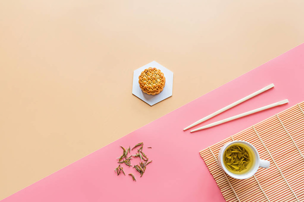 Flat lay of Chinese Festival dessert, Mid Autumn Festival Moon cake on colorful background with green tea and chopsticks. Top view, copy space, mockup, overhead, template - Zdjęcie, obraz