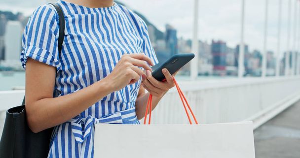 Женщина использование мобильного телефона с сумкой
 - Фото, изображение
