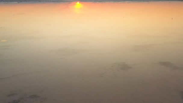 Drohne im orangen Morgengrauen über nebligem See. Der Himmel spiegelt sich gut im Wasser wider - Foto, Bild