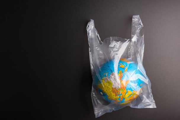 Plastic bag Earth world globe isolated on black background. Savi - Foto, Imagem