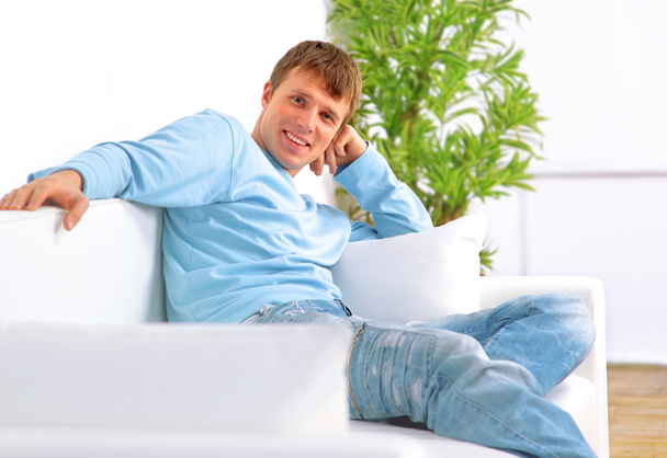 Man sitting in living room smiling - Foto, Imagem