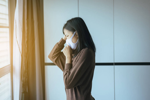 Młoda kobieta za pomocą maski ochrony PM 2.5, ponieważ zanieczyszczenie w domu, młoda kobieta dostał alergię na nos - Zdjęcie, obraz