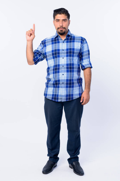 Full body shot of bearded Persian hipster man pointing up - Fotó, kép