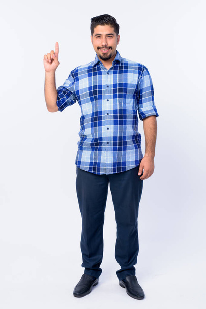 Full body shot of happy bearded Persian hipster man pointing up - Foto, Bild