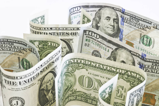 Amerikanische Währung - Ein-Dollar- und Hundert-Dollar-Scheine stehen auf einer hellen Oberfläche. - Foto, Bild