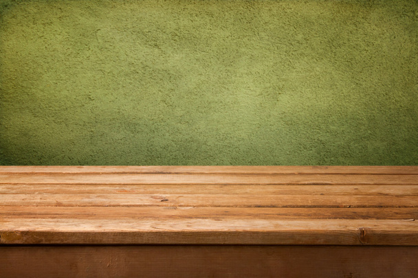 Empty wooden deck table over green wall background - Foto, afbeelding