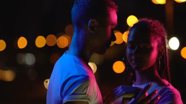 Loving teenage couple embracing in night lights, enjoying romantic atmosphere - Footage, Video