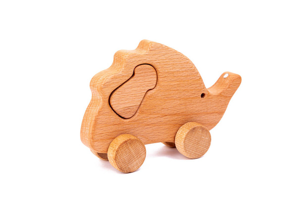 Photo d'un hérisson en bois avec champignon sur roues de hêtre. Jouet en bois sur un fond blanc isolé.Un jouet pour divertir les enfants et les parents au repos
 - Photo, image