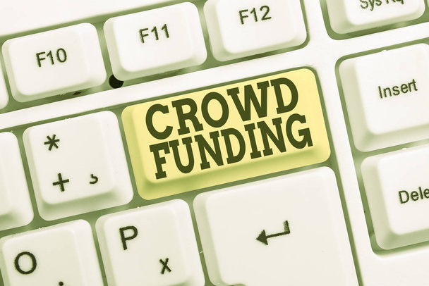 Escritura a mano conceptual que muestra Crowd Funding. Texto de la foto de negocios Recaudación de fondos Kickstarter Startup Pledge Platform Donaciones Teclado blanco para PC con papel de nota sobre el fondo blanco
. - Foto, imagen