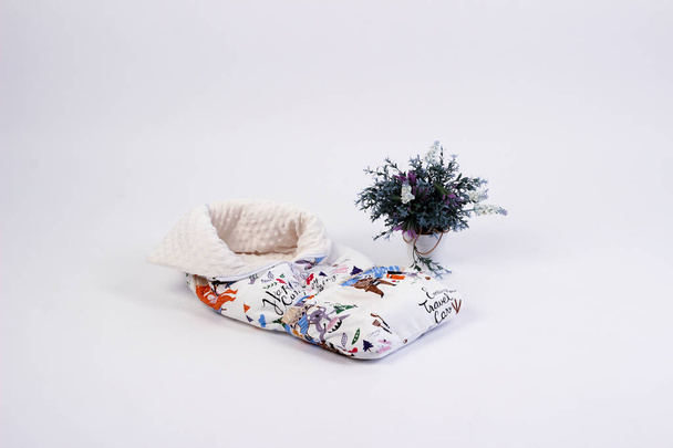 textiles for newborns in the photo Studio on a white background, the side of the pillow in a baby bed, blankets are transformed into envelopes for a walk, a cocoon for a comfortable and safe sleep of  - Valokuva, kuva