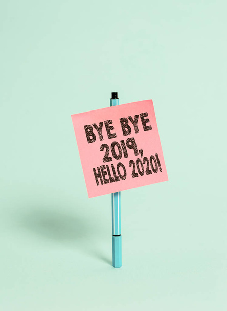 Kézírás szövege bye bye 2019 Hello 2020. Koncepció értelmében Búcsúzik az elmúlt évben, és üdvözölve egy jó egy BallPoint üres színes Öntapadó jegyzet békés hűvös pasztell divat háttér. - Fotó, kép