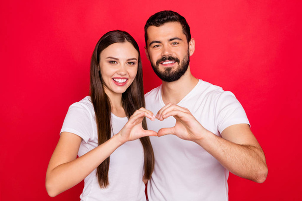 Photo of charming casual stylish cute lovely fascinating pretty spouses two people showing heart shape with their hands while isolated with red background - Fotografie, Obrázek