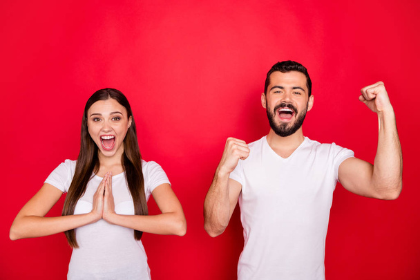 Photo of two stylish trendy rejoicing overjoyed excited people together ecstatic with having won something girlfriend wishing man shouting hooray wearing white t-shirt isolated with red background - Zdjęcie, obraz