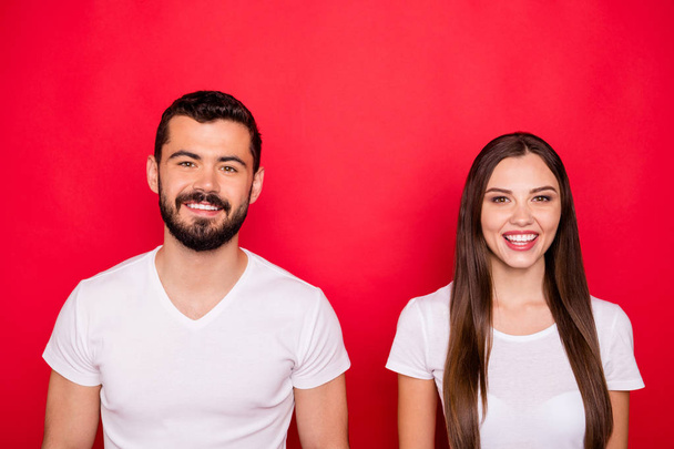 Photo of charming cute nice handsome beautiful couple looking at you while isolated with red backgroung with white t-shirts - Fotografie, Obrázek