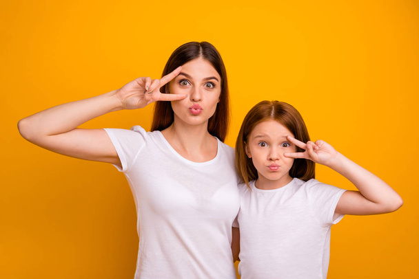 Portrait of two nice attractive comic childish funky cheerful glad positive person mommy showing v-sign having fun holiday isolated over bright vivid shine yellow background - Foto, afbeelding