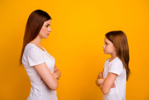 Profile side photo of negative mom and her child with long haircut looking wearing white t-shirt isolated over yellow background - Foto, imagen