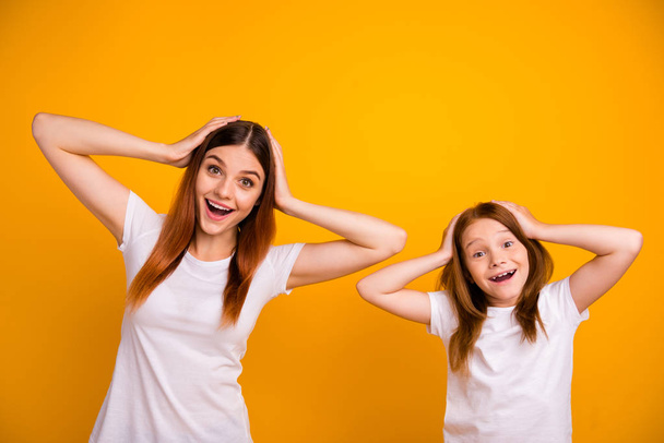Portrait of cute impressed people with long haircut screaming wow omg wearing white t-shirt isolated over yellow background - Photo, Image
