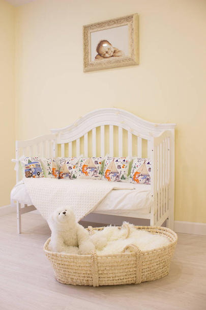textiles for newborns in the photo Studio in the interior of the nursery, side pillow in the crib, blankets turn into envelopes for walking, cocoon for a comfortable and safe sleep, baskets for toys - Φωτογραφία, εικόνα