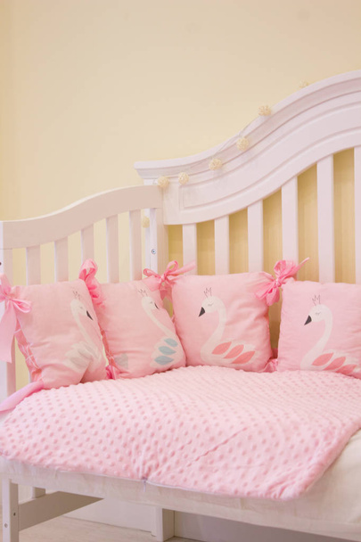 textiles for newborns in the photo Studio in the interior of the nursery, side pillow in the crib, blankets turn into envelopes for walking, cocoon for a comfortable and safe sleep, baskets for toys - Foto, Imagen