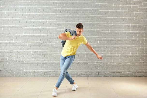 Beau jeune homme dansant contre un mur de briques
 - Photo, image