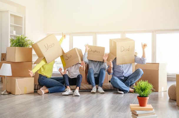 Famille heureuse avec des boîtes de déménagement s'amuser dans leur nouvelle maison
 - Photo, image