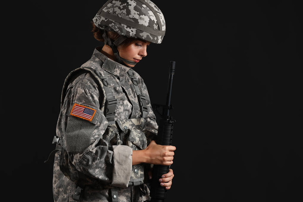 Young female soldier on dark background - Valokuva, kuva