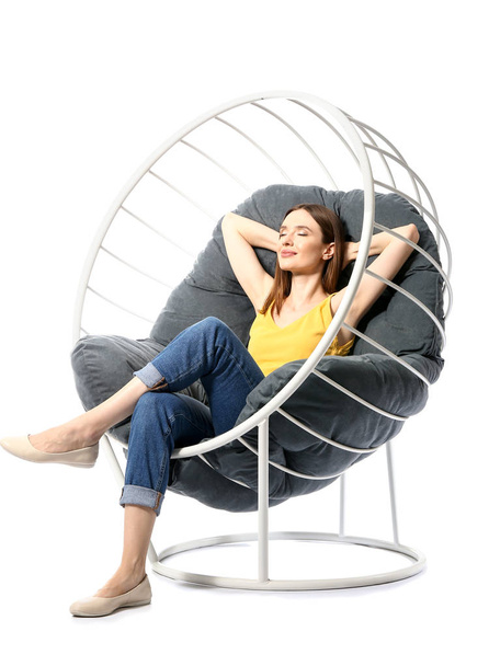 Young woman relaxing in armchair against white background - Foto, Imagen