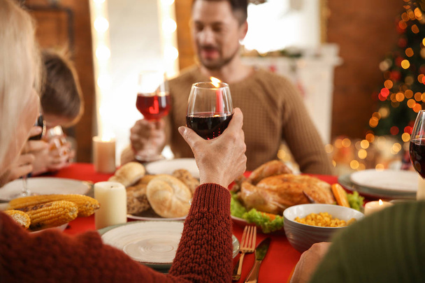 Ευτυχισμένη οικογένεια πίνοντας κρασί κατά τη διάρκεια χριστουγεννιάτικο δείπνο στο σπίτι - Φωτογραφία, εικόνα