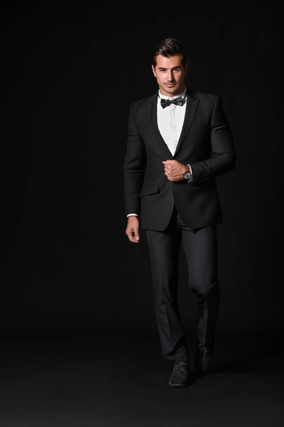 Fashionable man in formal clothes on dark background - Photo, image