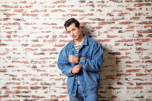 Stylish fashionable man near brick wall - Fotó, kép