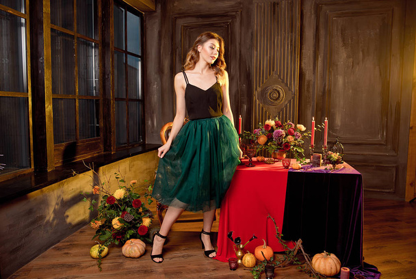 Happy Halloween.Attractive young woman getting ready for Halloween by setting the table for a festive dinner. Beautiful woman pumpkin. - Photo, image